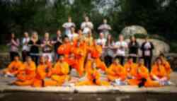 A group of travellers with Kung Fu practitioners in orange outfits