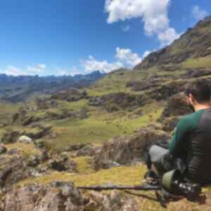 A traveller sitting on a rock overlooking mountains