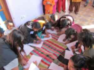 Schoolchildren on the floor writing on paper