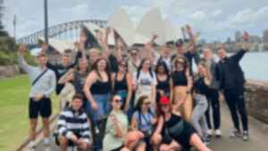 Group of travellers in front of the Sydney Opera House and Sydney Harbour Bridge, Australia