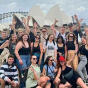 Group of travellers in front of the Sydney Opera House and Sydney Harbour Bridge, Australia