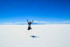Person jumping at salt flats, Salar de Uyuni, Bolivia