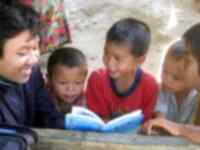 A lady reading a book to a group of children