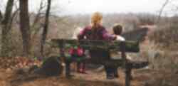 A person sitting on a bench with two children