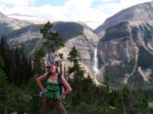 Gillian standing in front of a waterfall set into a large mountain