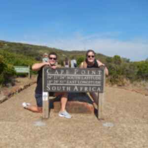Two people behind Cape Point sign in Cape Town, South Africa 