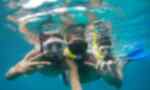 Three travellers underwater in scuba gear