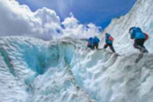 Four people climbing a glacier