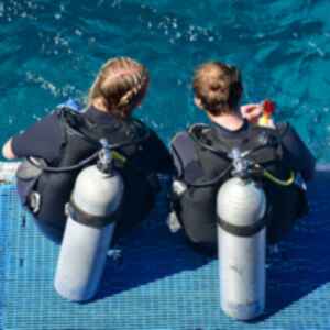 Two people sat before scuba diving the Great Barrier Reef, Australia