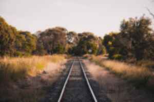 Train tracks running through dry bushland in rural Australia