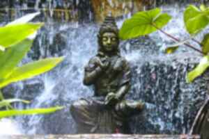 A Buddha statue under falling water at Wat Saket (Golden Mount) in Bangkok